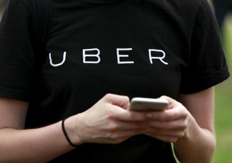 Uber representative registers people on smartphone during kick off of citywide jobs tour in Queens borough of New York