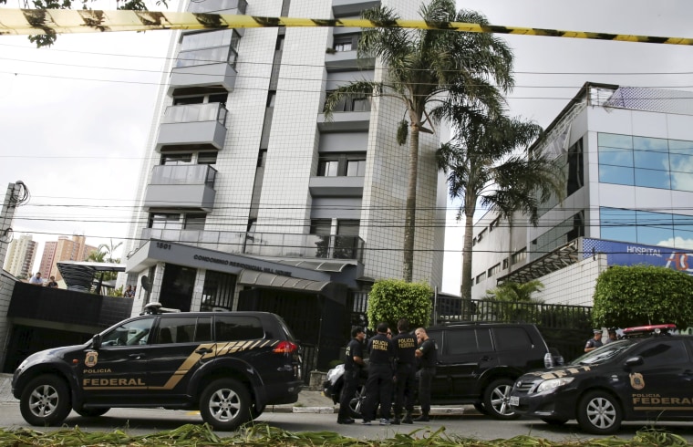 Image: Federal police officers stand in front of the apartment building that former Brazilian President Luiz Inacio Lula da Silva lived in Sao Bernardo do Campo