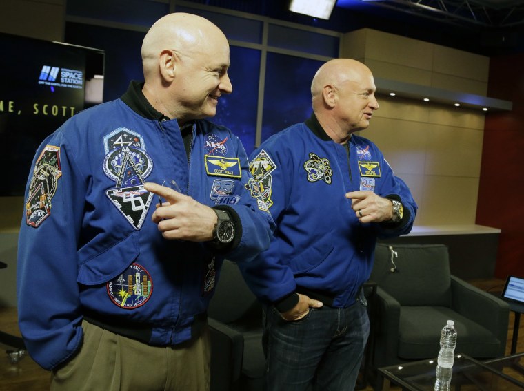 NASA astronaut Scott Kelly, left, and his identical twin Mark, a retired NASA astronaut, stand together before a news conference in Houston. Scott Kelly set a U.S. record with his 340-day mission to the International Space Station.