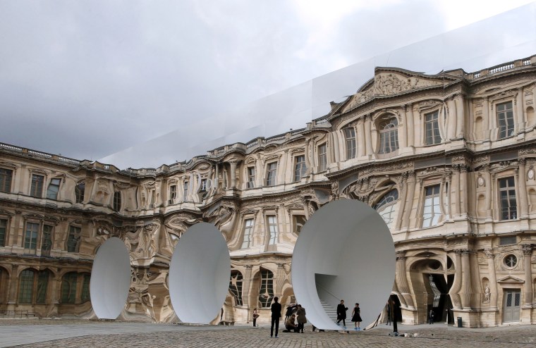 The Louvre Museum is reflected in the venue as guests arrive for the Christian Dior fashion show during the 2016-2017 fall/winter ready-to-wear collection in Paris.