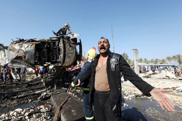 Image: A man reacts at the site of a bomb attack at a checkpoint in the city of Hilla