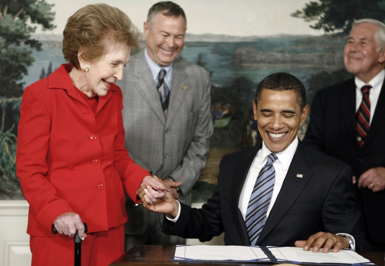 Image: President Barack Obama clasps the hand of former first lady Nancy Reagan