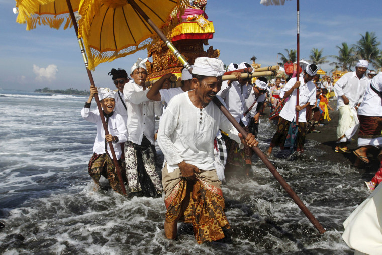 Image: Balinese Hindus carry Pratimas, or symbols of God, on the beach during Melasti, a purification ceremony, ahead of the holy day of Nyepi, in Gianyar