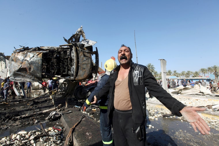 Image: A man reacts at the site of a bomb attack at a checkpoint in the city of Hillah