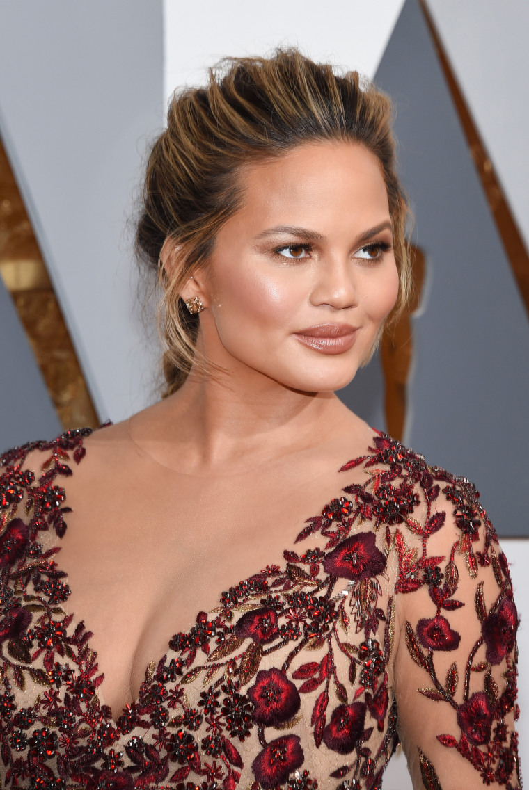 Chrissy Teigen rocks red eye makeup at the 88th Annual Academy Awards
