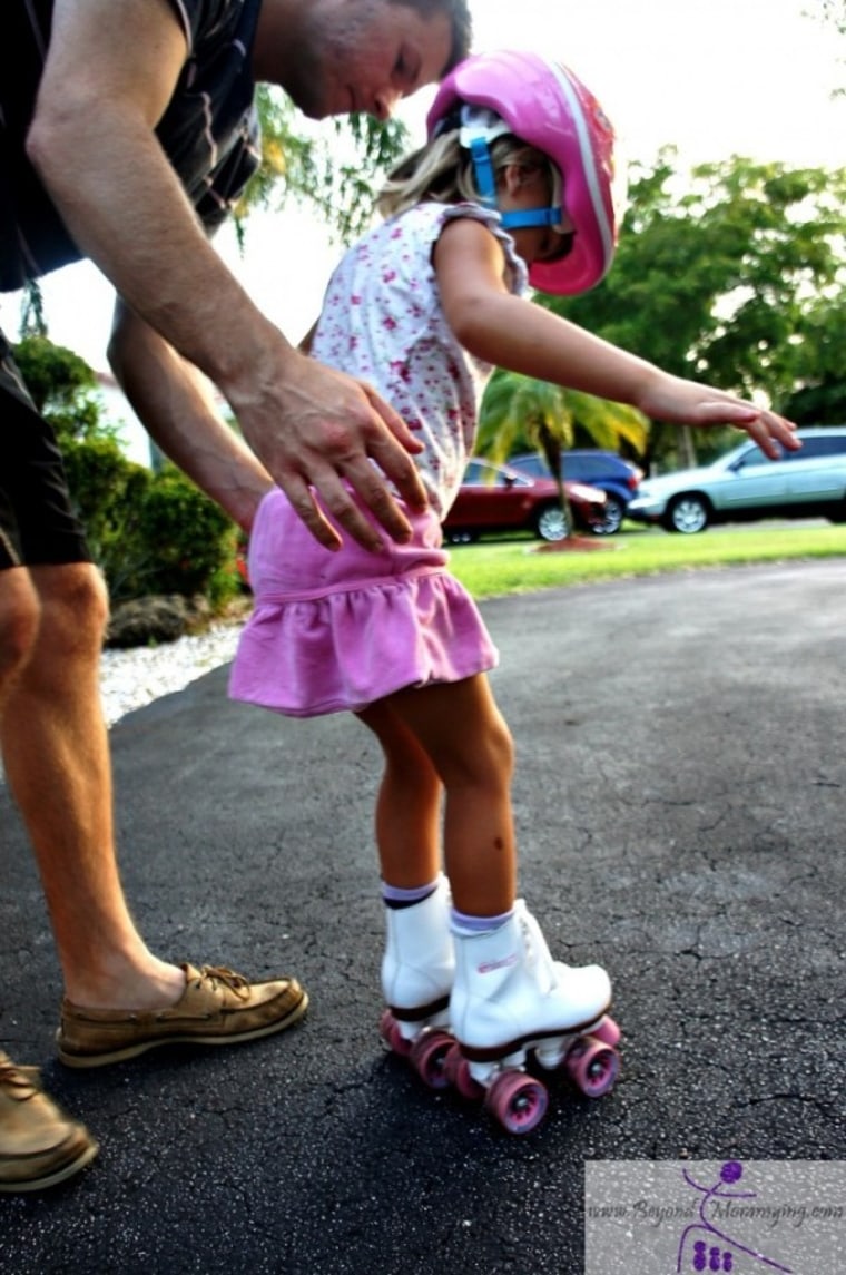 Dad helping daughter rollerskate