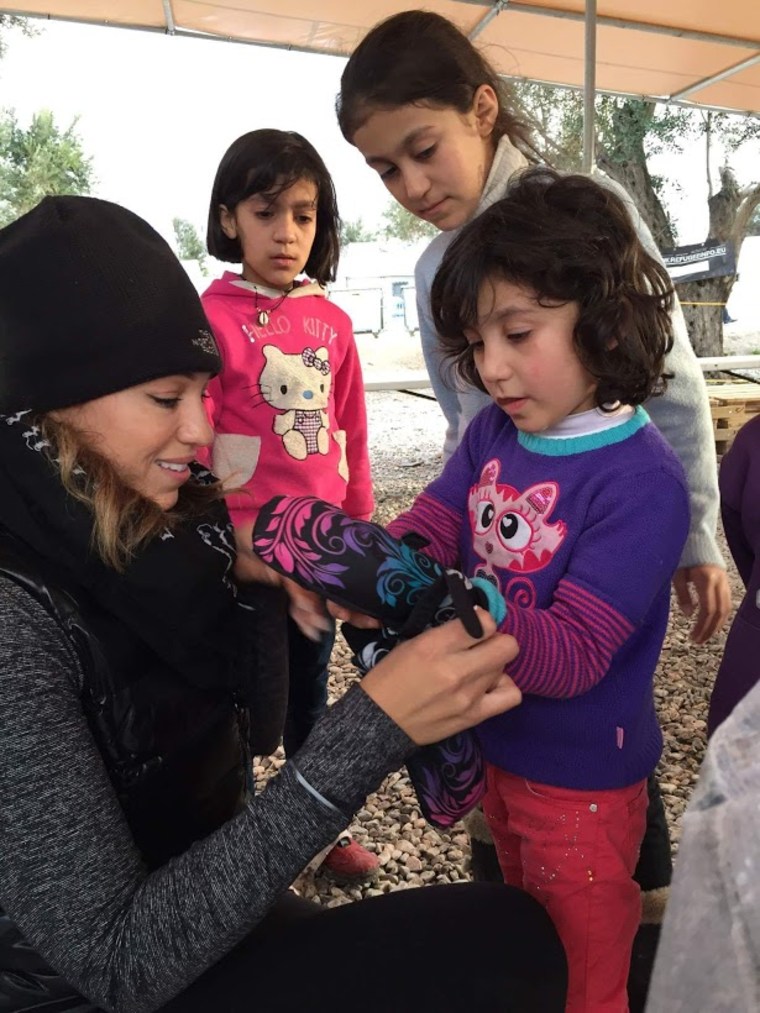 Somer Sood selects a glove for Mariam, a girl from Homs, Syria, at the Kara Tepe camp in Lesvos, Greece.