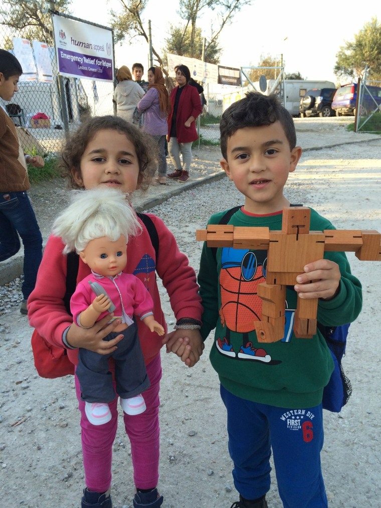 This brother and sister at a camp in Lesvos smile after receiving toys.