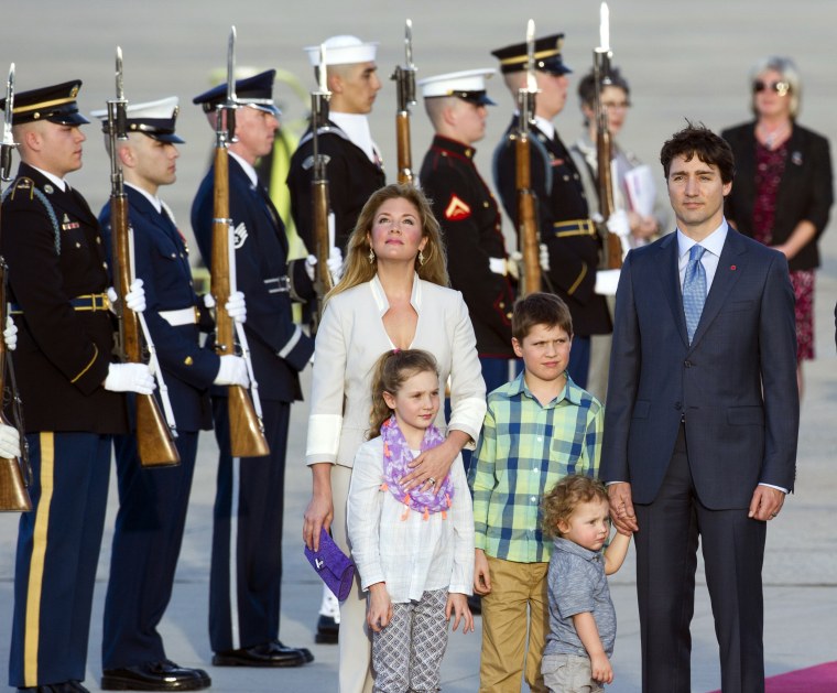 Canadian Prime Minister Justin Trudeau, his wife Sophie Grégoire-Trudeau and their children stand for the playing of the Canadian and United States National Anthems after their arrival at Andrews Air Force Base, Md., Wednesday, March 9, 2016. (AP Photo/Cliff Owen)