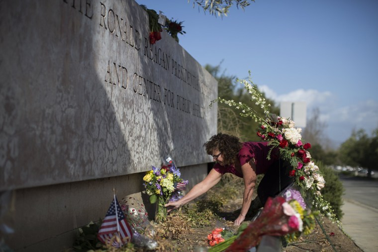 Image: Monika Poach arranges flowers left in memory of former first lady Nancy Reagan