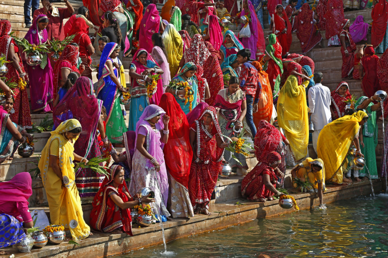 Image: Hindu women collect water from the Pushkar lake to pour on idols of Lord Shiva