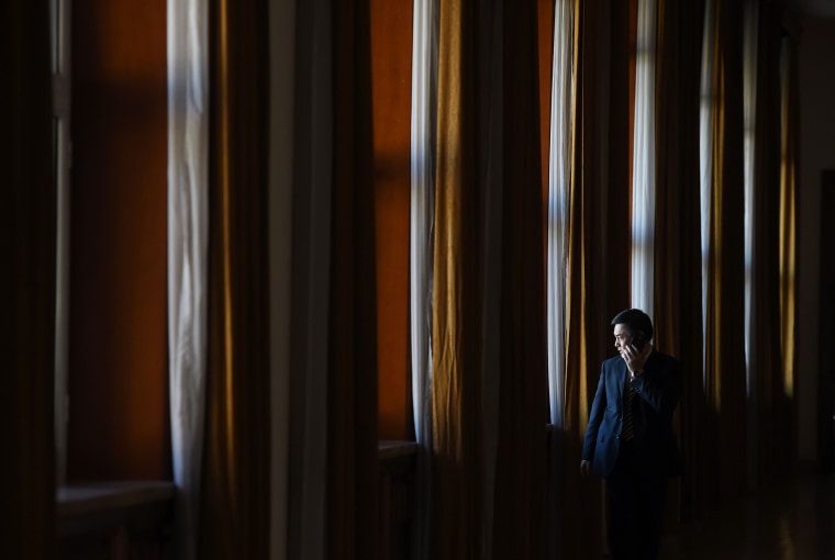 Image: An official makes a phone call outside a group meeting for Tibetan delegates