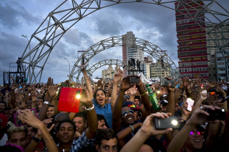Image: Fans dance and take pictures with their mobile phones during a free concert in Havana