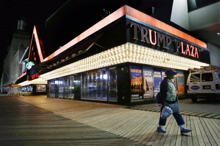 A woman passes burned-out lights at the Trump Plaza Hotel &amp; Casino on The Boardwalk in Atlantic City, N.J., on Sept. 16, 2014. 