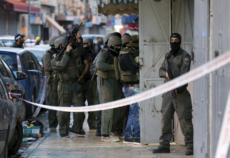Image: Israeli security forces search the scene where an Israeli police spokesperson said a Palestinain shooting attack on Israeli policemen took place, just outside Jerusalem's Old city