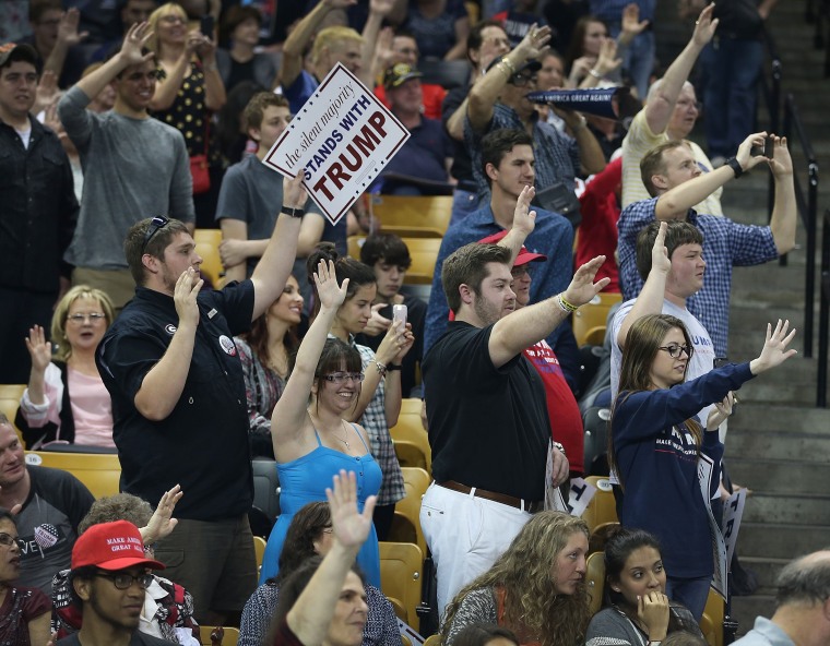 Image: Donald Trump supporters raise their arms to pledge support for the candidate