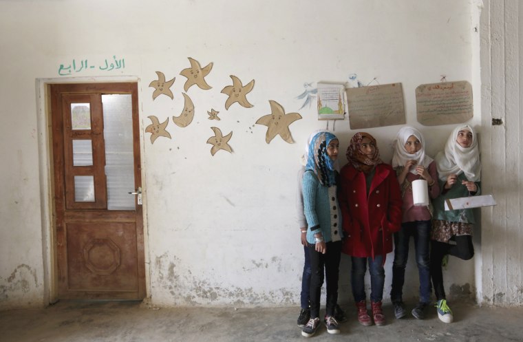 Image: Students hold geometrical forms to decorate the Freedom School, in the town of al-Tamanah, in the southern countryside of Idlib