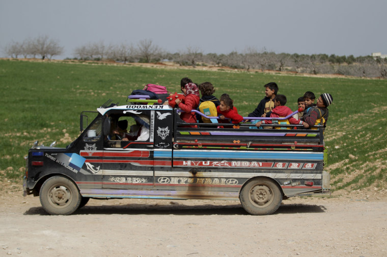 Image: Students ride on a pick-up truck after leaving the Freedom School, in the town of al-Tamanah, in the southern countryside of Idlib
