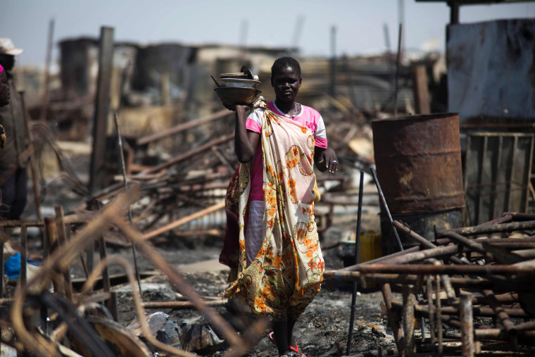 Image: A displaced women residing in the United Nations Protection of Civilians (PoC) site in Malakal, examines a burnt and looted area