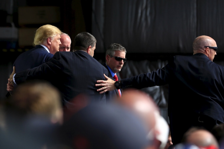 Image: Secret Service agents surround U.S. Republican presidential candidate Trump during a disturbance as he speaks at Dayton International Airport in Dayton, Ohio