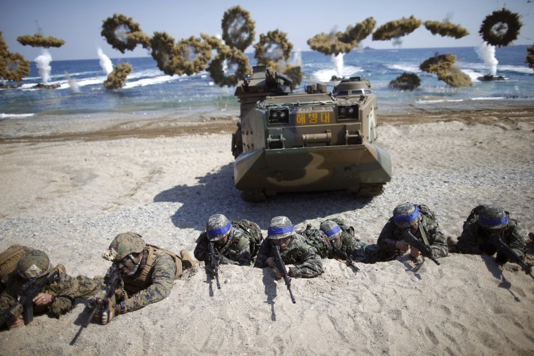 Image: South Korean and U.S. Marines take positions as amphibious assault vehicles of the South Korean Marine Corps fire smoke bombs during a U.S.-South Korea joint landing operation drill in Pohang
