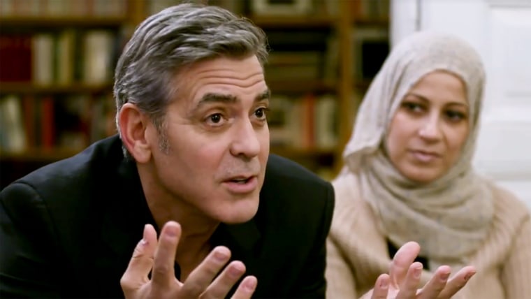 George Clooney speaking with Syrian refugees in Berlin.