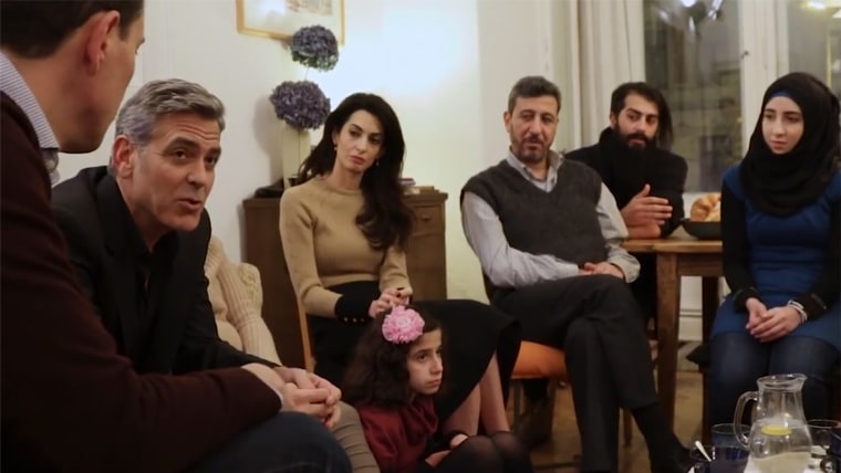 George and Amal Clooney speaking with Syrian refugees in Berlin.