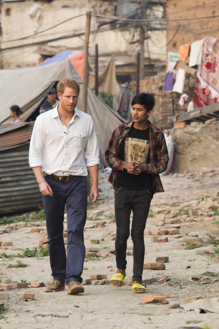 Prince Harry is shown around by 15-year-old Purushottam Suwal, chair person of the Buyansi Camp.