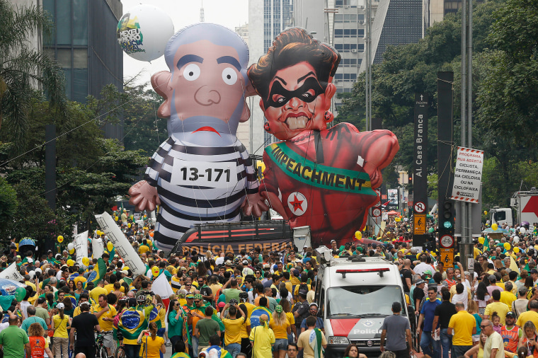 Image: Demonstrators parade large inflatable dolls depicting Brazil's former President Luiz Inacio Lula da Silva