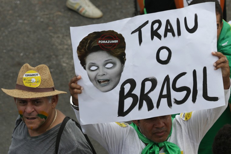 Image: A woman holds a poster showing Brazil's President Roussef