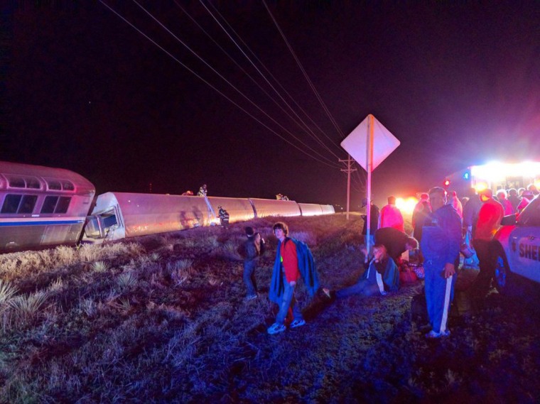 Image: Passengers gather after a train derailed near Dodge City