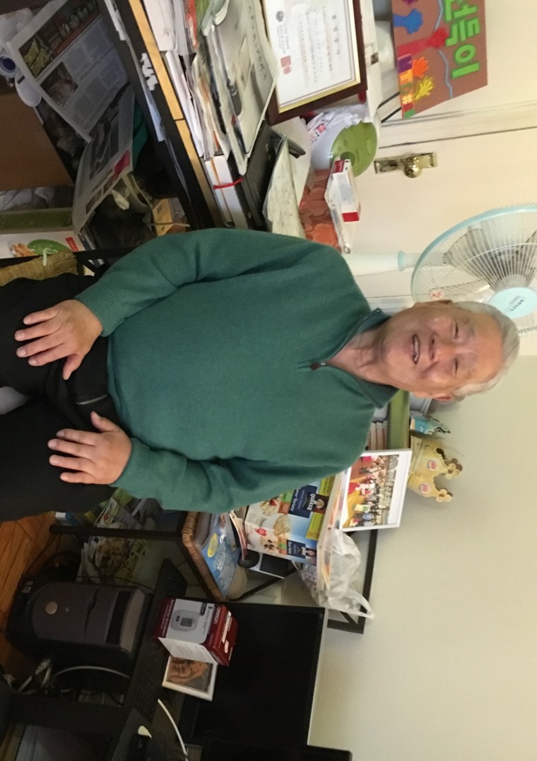 Han Tak Lee seated among his collected reading materials in his Queens studio. Lee was released from prison August 2014 after spending 24 years imprisoned for a crime he was falsely convicted for.