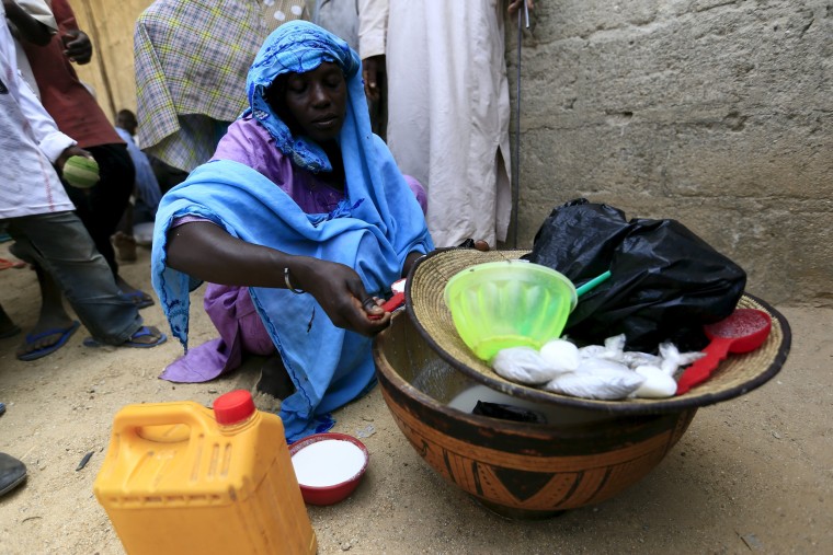 Image: A woman sells milk at a community of internally displaced people