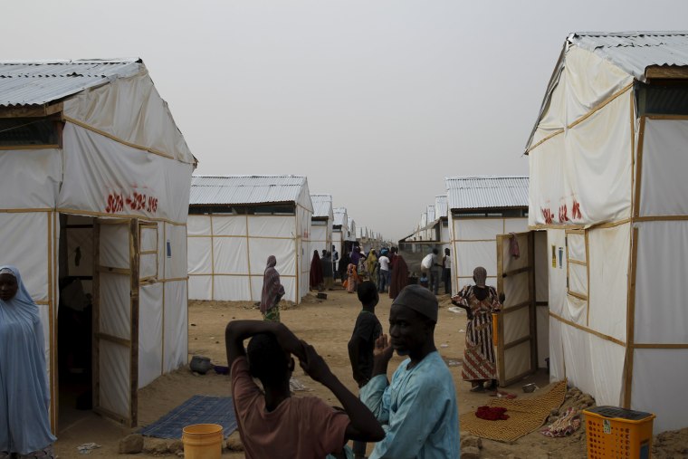 Image: People walk near makeshift accommodation at Bakassi Camp for internally displace people