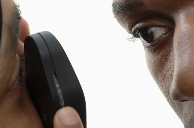 GP using ophthalmoscope to examine young mans eye