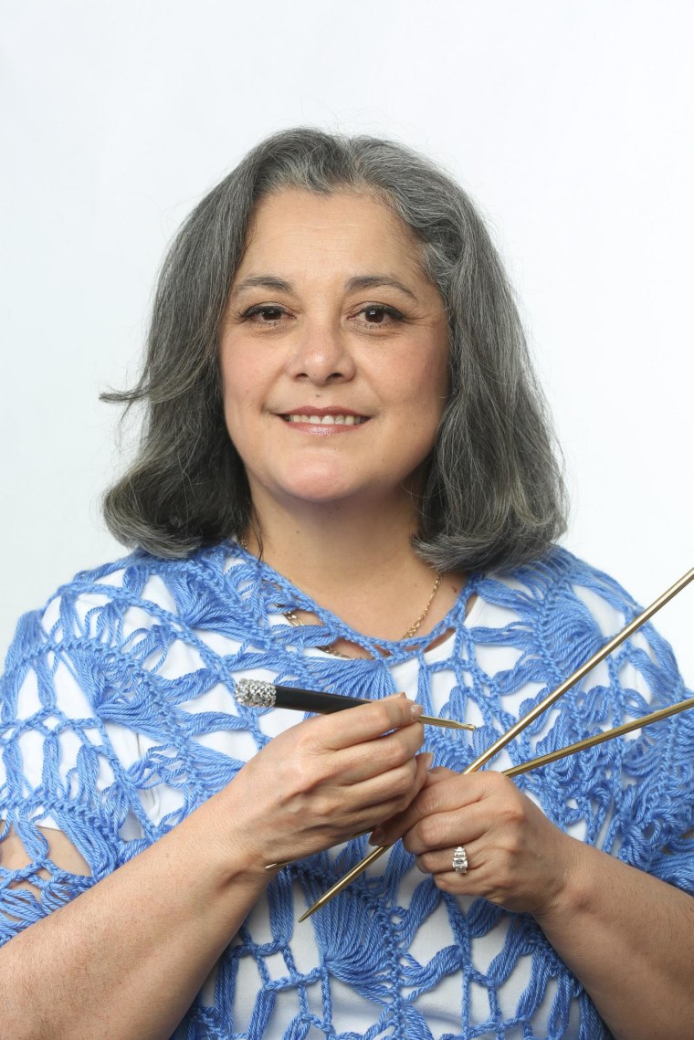 Yolanda Soto-Lopez holding knitting needles and a hook.