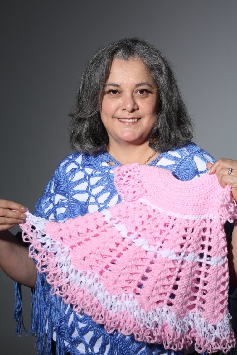 Yolanda Soto-Lopez holding a pink dress she made on her channel.