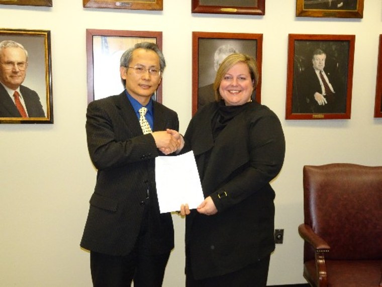 Scott Lai, the director general of the Taipei Cultural and Economic Office in Boston, shaking hands with Erin Deveney, the Massachusetts interim registrar of motor vehicles.