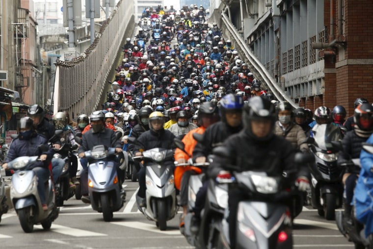 Image: Motorists ride to work on a bridge during morning rush hour in Taipei, Taiwan