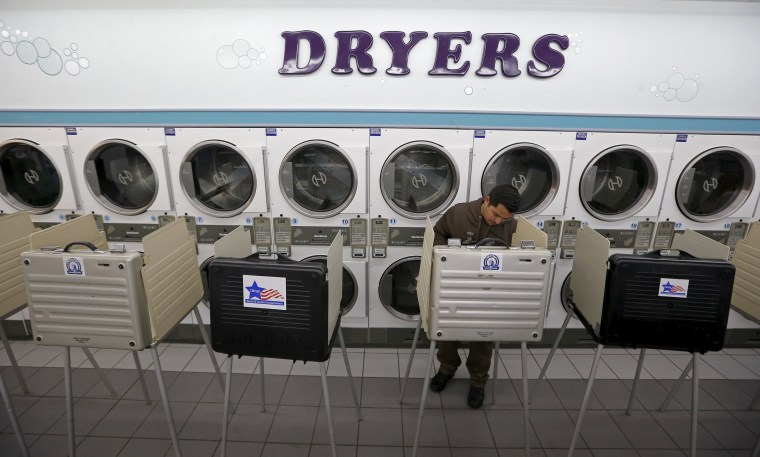 Image: A voter casts a ballot at Su Nueva laundromat during voting in Illinois' U.S. presidential primary election in Chicago