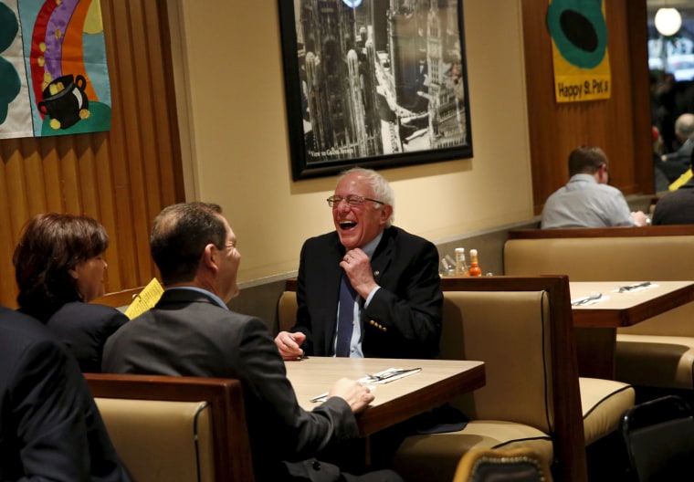 Image: Democratic U.S. presidential candidate Bernie Sanders laughs after sitting down for breakfast at Lou Mitchell's Restaurant in Chicago, Illinois