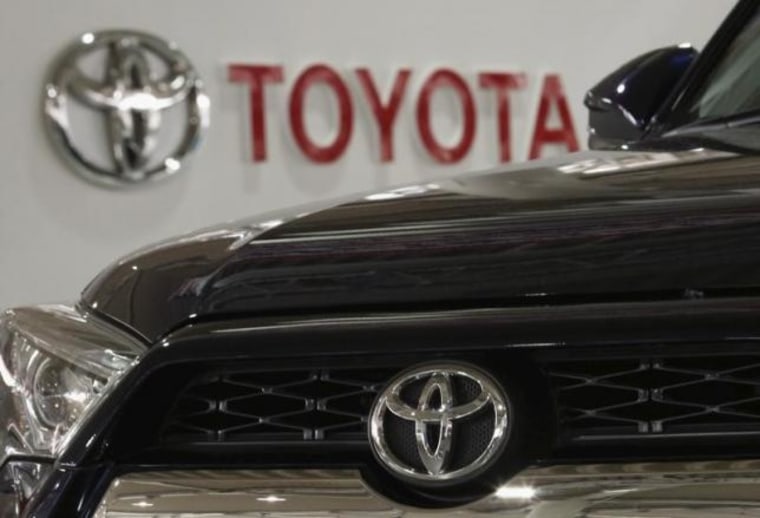 A logo of Toyota Motor Corp is pictured on a car and the background at the company's showroom in Tokyo