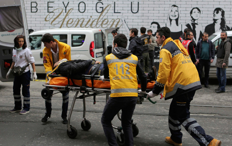 Image: Man is helped by emergency services members following a suicide bombing in central Istanbul
