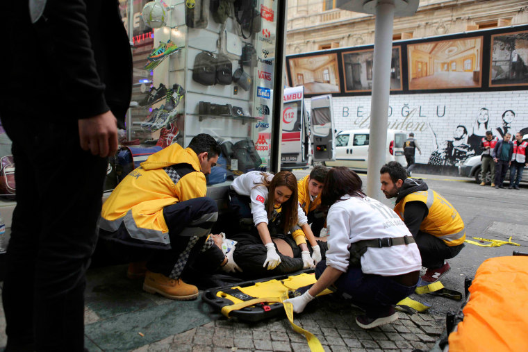 Image: Man is helped by emergency services members following a suicide bombing in central Istanbul