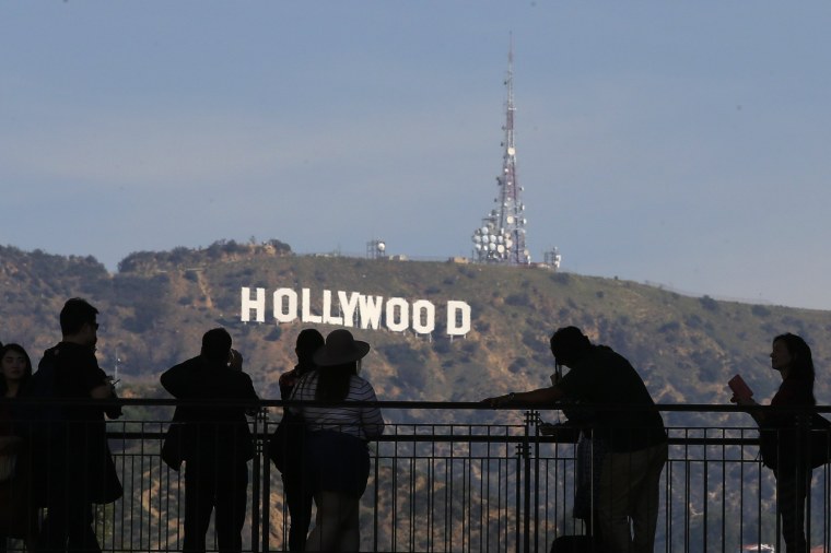 Image: People look on and photograph the famed Hollywood sign as preparations continue for the 88th Academy Awards in Hollywood, Los Angeles