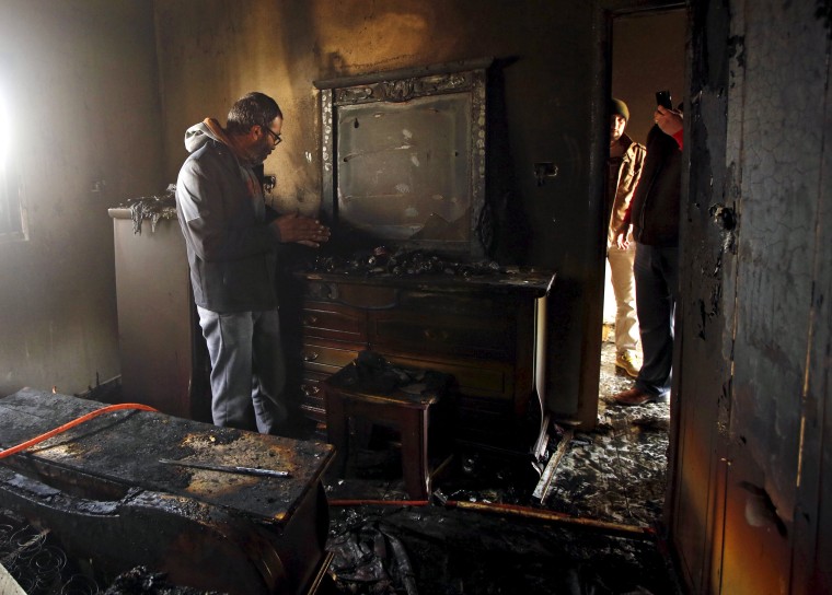 Image: Palestinian man inspects the damage to the torched house of Ibrahim Dawabsheh, the main witness in the July arson attack, in the West Bank village of Duma