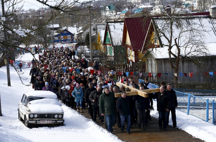 Image: Belarussian Catholics carry a wooden cross as they take part in a procession celebrating Palm Sunday in the town of Oshmiany