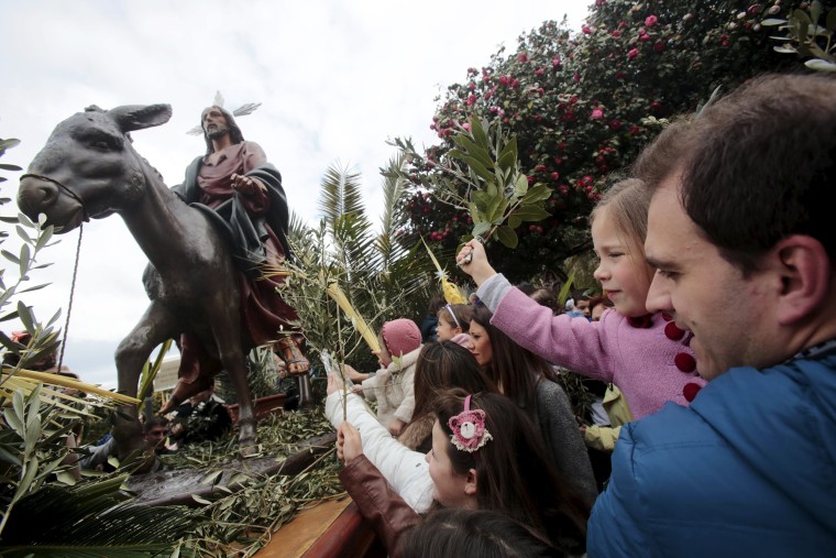 Image: Spanish Catholics carry a devotional image of 'La Borriquita' during a Palm Sunday procession in Pontevedra