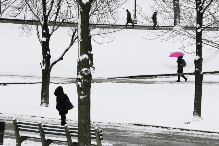 Image: Pedestrians walk on Boston Common during a snow storm on the second day of spring in Boston