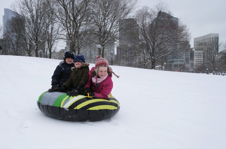 Image: Siblings Leo, Max and Zoe Zavrachy ride down a snow covered hill on Boston Common during a snow storm on the second day of spring in Boston